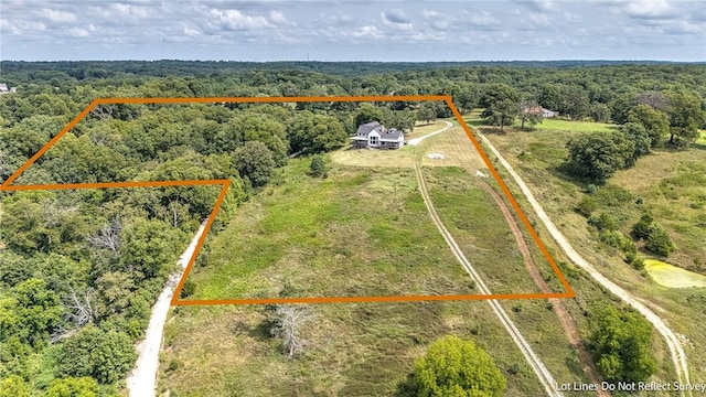 aerial view of property and surrounding area featuring property boundaries highlighted and a forest
