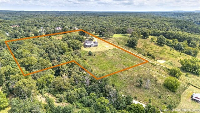 aerial view of property's location with a heavily wooded area and property boundaries highlighted