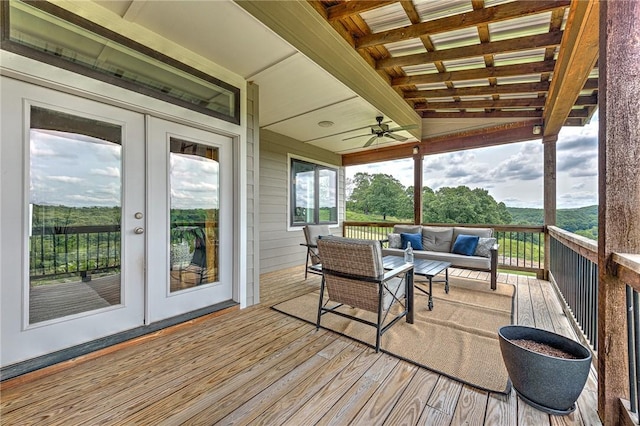 wooden deck with an outdoor living space, ceiling fan, and french doors