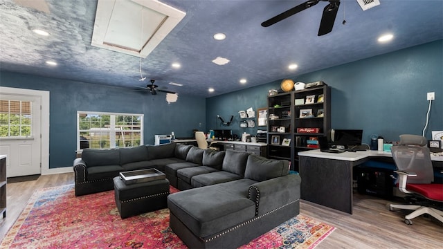 living room featuring light hardwood / wood-style floors and ceiling fan