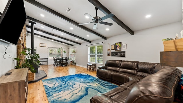 living room featuring light hardwood / wood-style floors, ceiling fan, and vaulted ceiling with beams