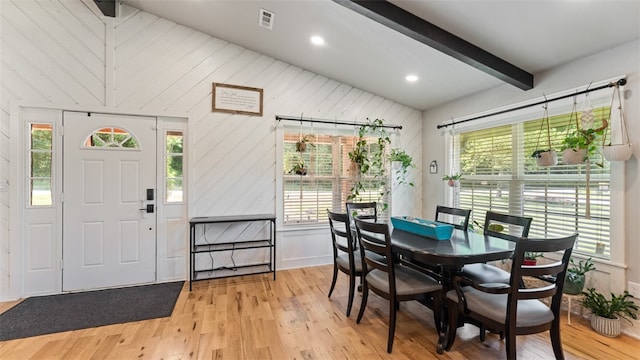 dining room featuring light hardwood / wood-style floors, lofted ceiling with beams, and a wealth of natural light