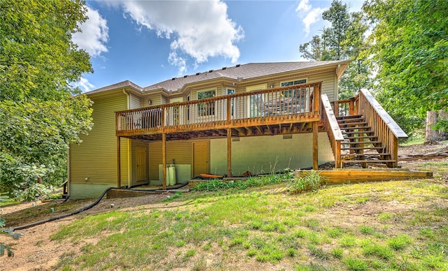 rear view of house with a deck and a lawn