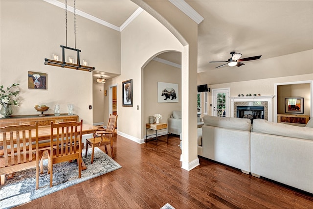 dining area featuring a high end fireplace, dark wood-type flooring, ceiling fan, and ornamental molding