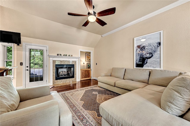 living room with a fireplace, ceiling fan, crown molding, hardwood / wood-style floors, and vaulted ceiling