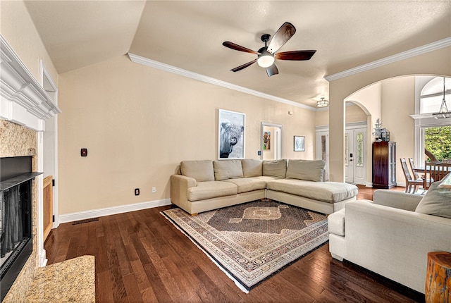 living room featuring ceiling fan, dark hardwood / wood-style flooring, lofted ceiling, and ornamental molding