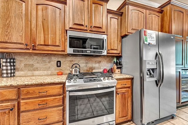 kitchen featuring decorative backsplash, appliances with stainless steel finishes, light stone counters, and light tile patterned floors