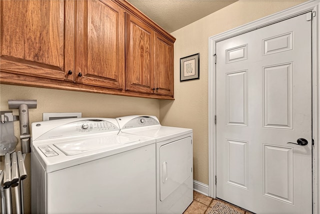 laundry room with light tile patterned floors, independent washer and dryer, and cabinets