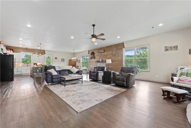 living room with ceiling fan, dark hardwood / wood-style flooring, and a wealth of natural light