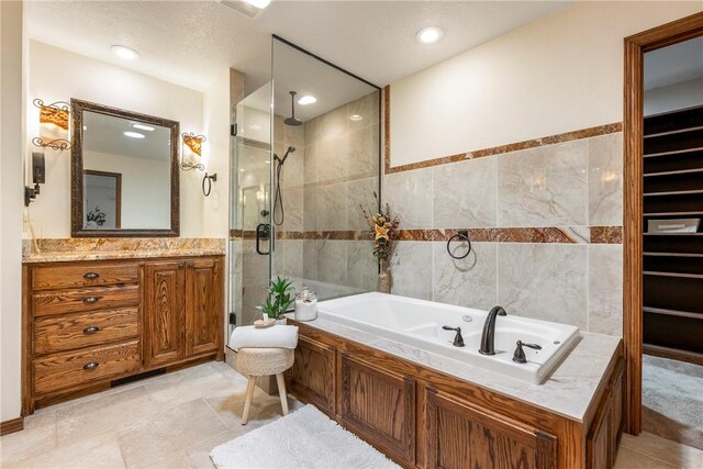 bathroom with shower with separate bathtub, vanity, and tile walls