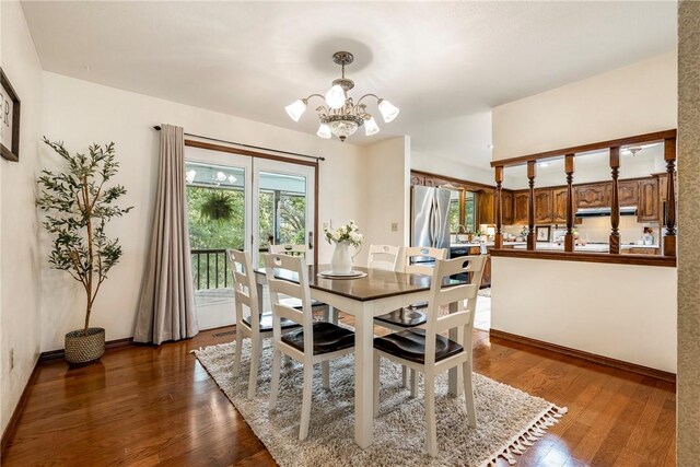 dining area with dark wood-type flooring and a notable chandelier