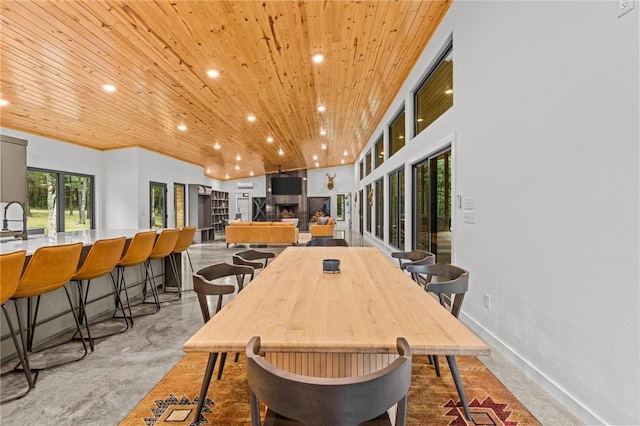 dining room with sink, a fireplace, and wooden ceiling