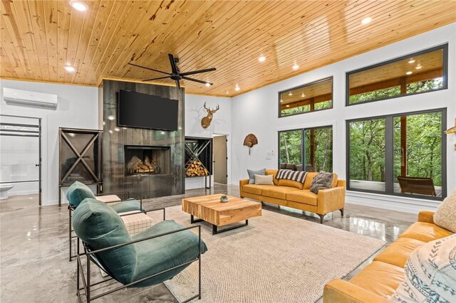 living room with an AC wall unit, wooden ceiling, a tiled fireplace, and ceiling fan