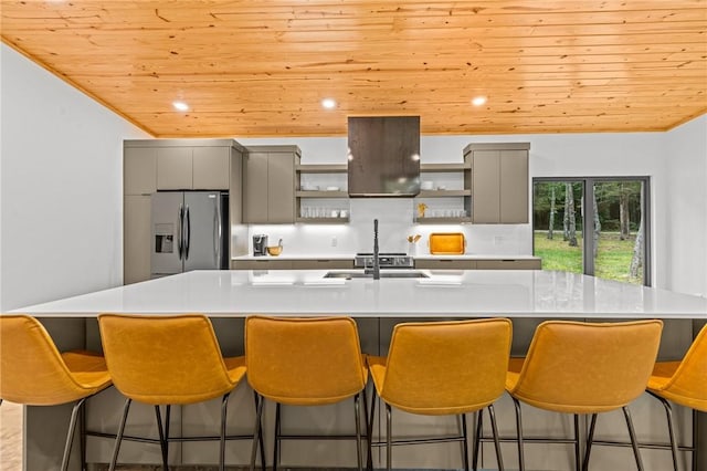 kitchen featuring gray cabinets, a large island, a kitchen bar, and stainless steel fridge with ice dispenser