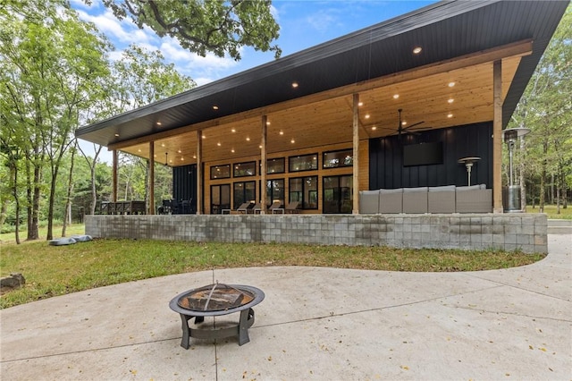 back of property featuring an outdoor living space with a fire pit, a patio, and ceiling fan