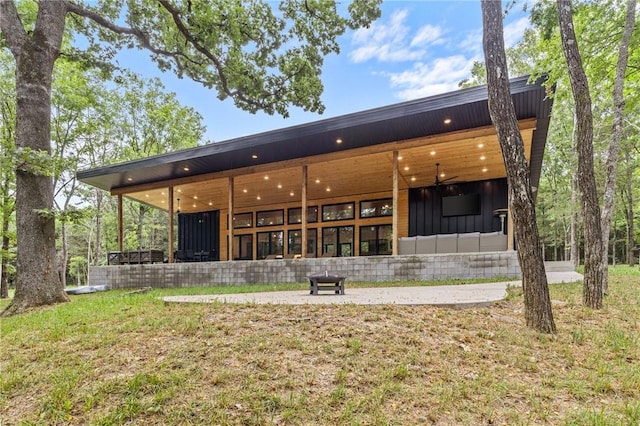 back of house featuring ceiling fan and a lawn