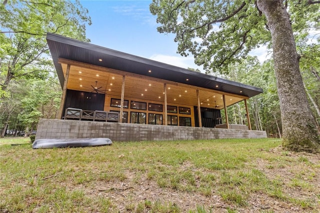 rear view of property featuring ceiling fan