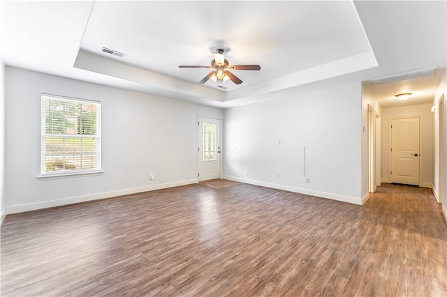 unfurnished room with ceiling fan, hardwood / wood-style flooring, and a raised ceiling