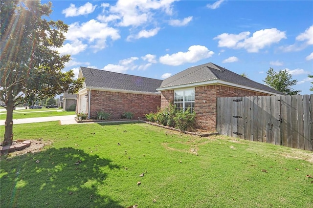 view of side of home with a garage and a lawn