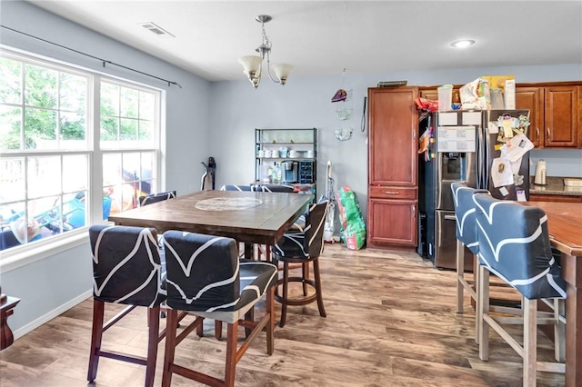 dining area with hardwood / wood-style flooring and a chandelier