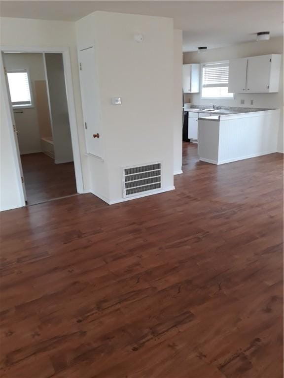 unfurnished living room with dark hardwood / wood-style flooring