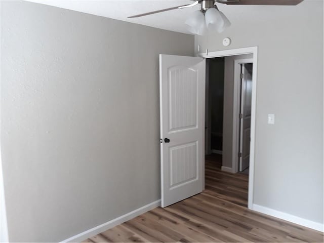 unfurnished room with ceiling fan and dark hardwood / wood-style flooring