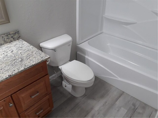 full bathroom with vanity, hardwood / wood-style flooring, toilet, and shower / bathtub combination