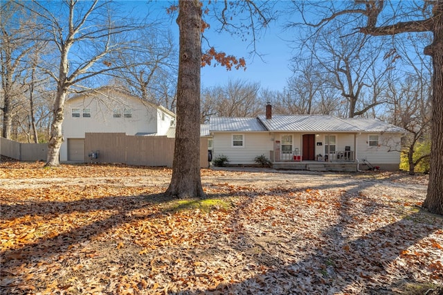 back of house with a porch and a garage