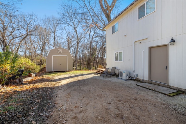 view of side of home featuring ac unit and a storage shed