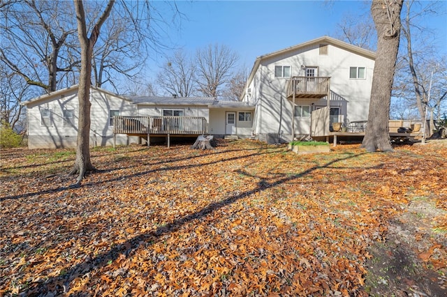 rear view of house with a balcony and a wooden deck