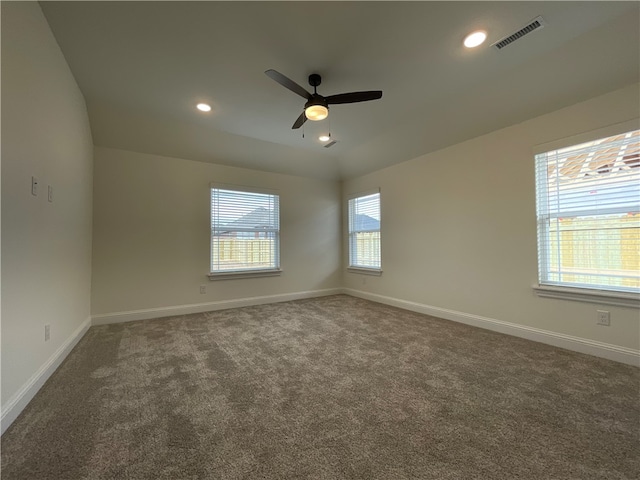 carpeted spare room featuring ceiling fan, lofted ceiling, and plenty of natural light