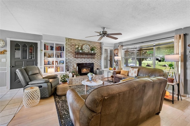 living room with a textured ceiling, light hardwood / wood-style flooring, and ceiling fan