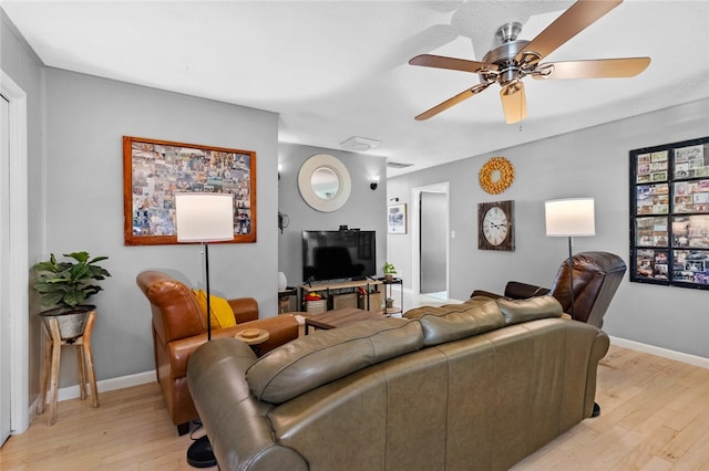 living room with ceiling fan and light hardwood / wood-style flooring