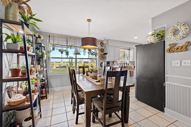 tiled dining area featuring plenty of natural light and a textured ceiling