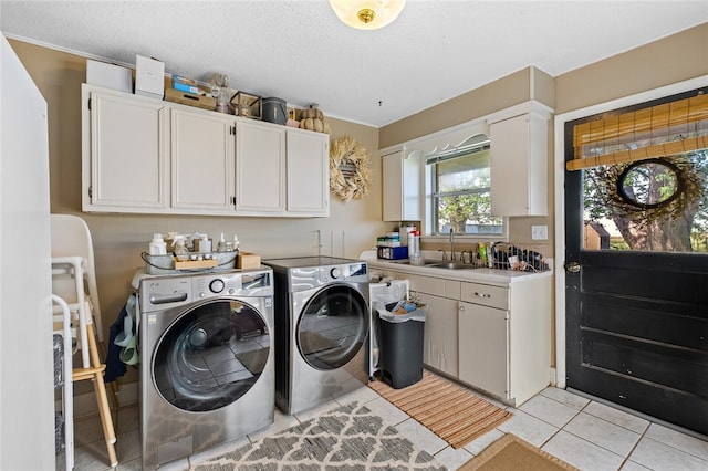 laundry room featuring cabinets, a textured ceiling, sink, separate washer and dryer, and light tile patterned flooring