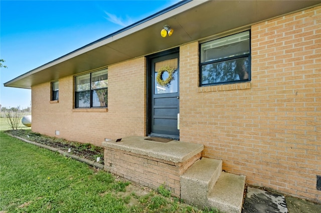 property entrance featuring a lawn