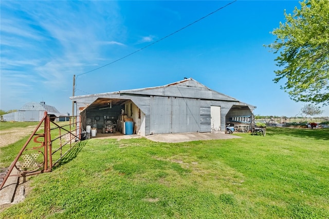 rear view of property with a lawn and an outbuilding