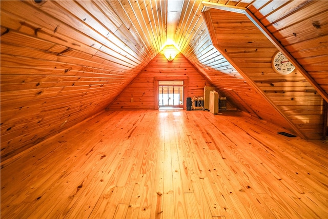 bonus room featuring light wood-type flooring, lofted ceiling, wooden ceiling, and wooden walls