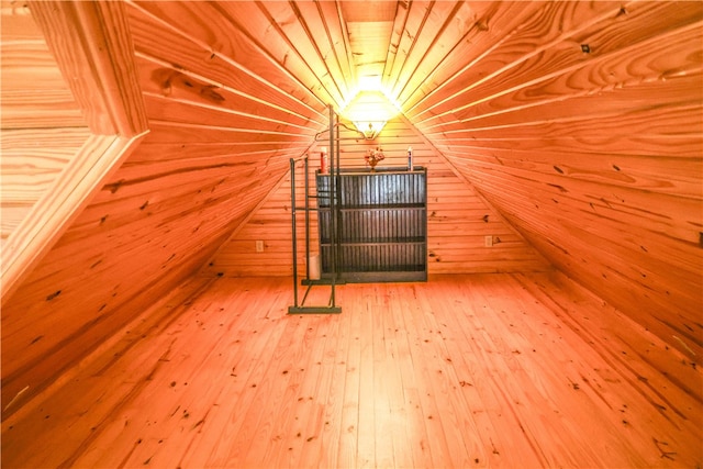 bonus room with wooden walls, lofted ceiling, hardwood / wood-style flooring, and wooden ceiling