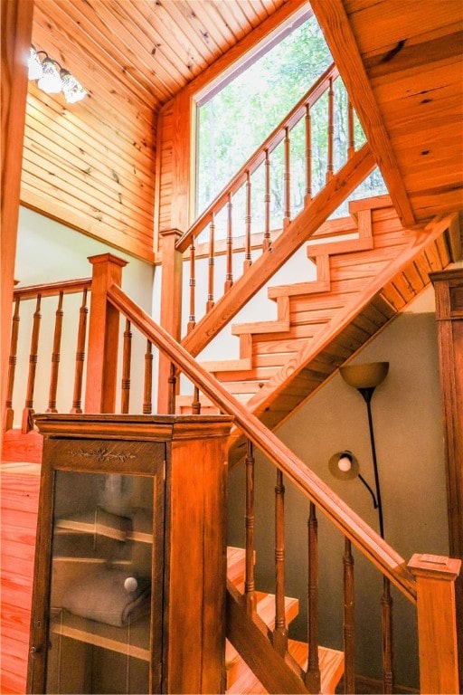 stairway featuring wood ceiling, wood-type flooring, and vaulted ceiling