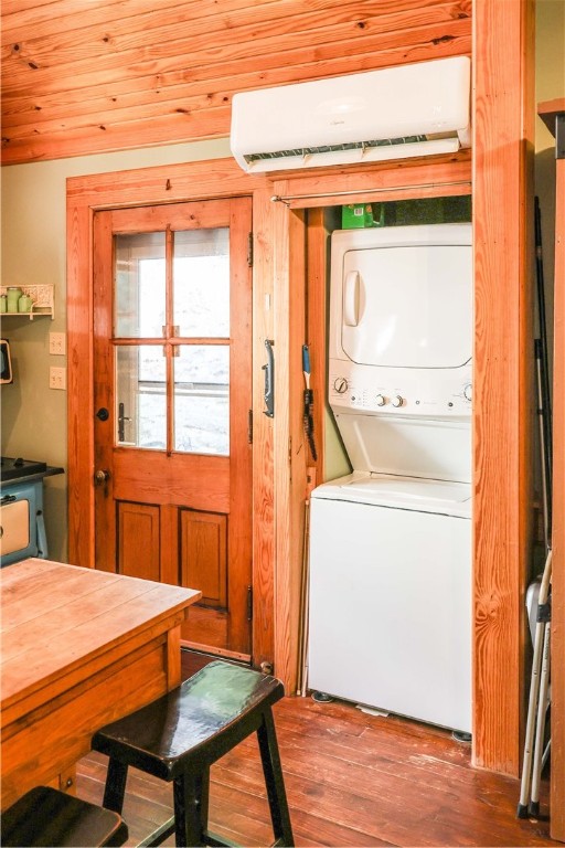 clothes washing area featuring wood-type flooring, wood ceiling, stacked washer and dryer, and an AC wall unit