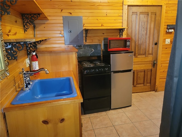 kitchen featuring electric panel, sink, wood walls, appliances with stainless steel finishes, and light tile patterned floors