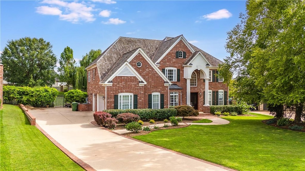 view of front of home featuring a front lawn, concrete driveway, and brick siding