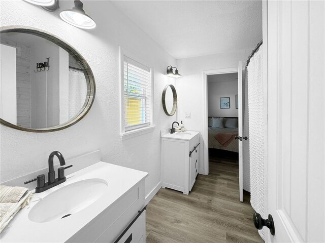 bathroom with double vanity and hardwood / wood-style floors