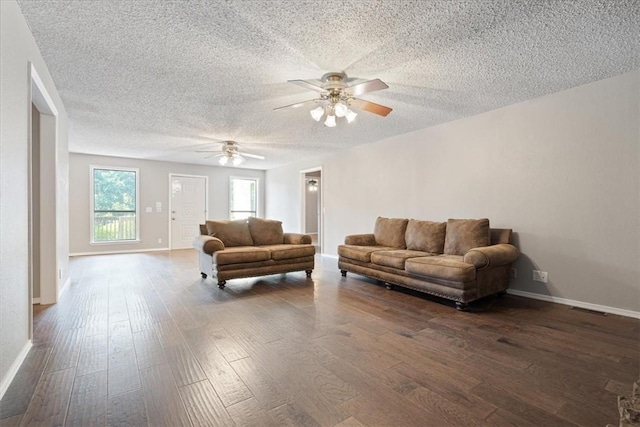 living room with dark wood finished floors, a textured ceiling, baseboards, and ceiling fan