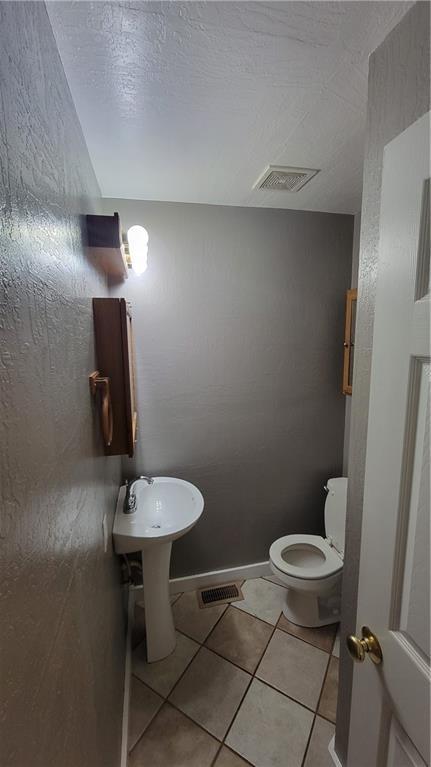 3810 Rainbow Farm Rd, Bentonville, AR 72713 - bathroom with tile patterned floors, toilet, and a textured ceiling
