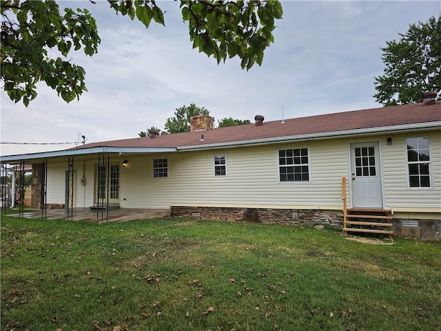 back of property with a patio area and a lawn