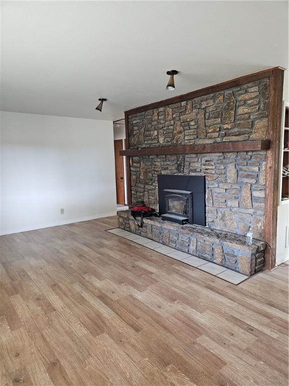 unfurnished living room featuring light hardwood / wood-style floors and a wood stove