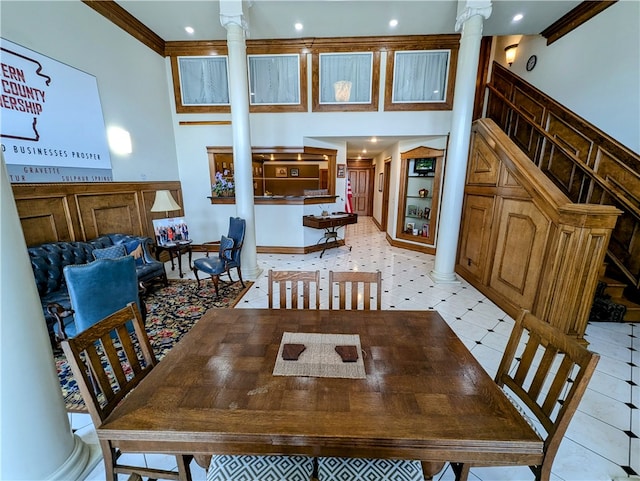 dining room featuring light tile patterned flooring, ornamental molding, and ornate columns