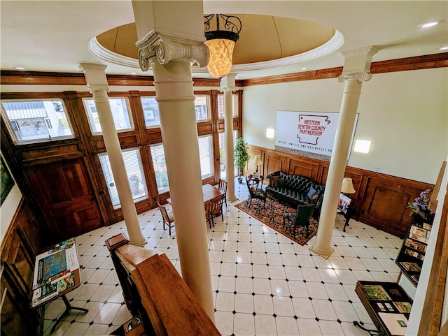 foyer with decorative columns, a raised ceiling, and light tile patterned floors